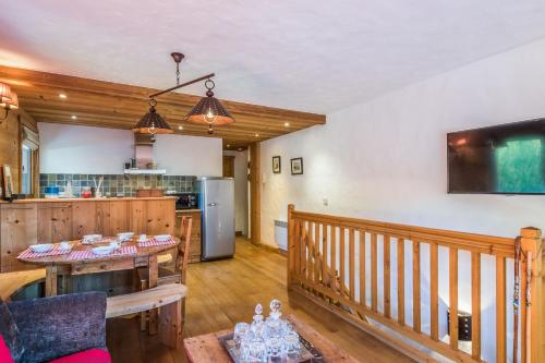ein Wohnzimmer mit einem Tisch und einer Küche in der Unterkunft Charming flat in a chalet in Megève - Welkeys in Megève