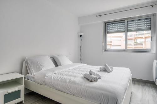 une chambre blanche avec un lit avec des serviettes dessus dans l'établissement Appartement Antoinette - Welkeys, à Antibes