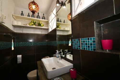 a bathroom with a sink and a toilet and a mirror at Villa Lorizon in Rodrigues Island