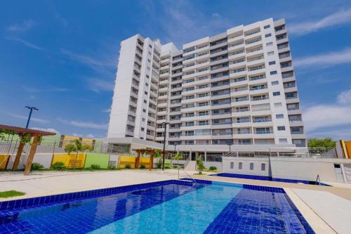 un gran edificio de apartamentos blanco con piscina en CALDAS NOVAS - RECANTO DO BOSQUE Flat Service AP209 en Caldas Novas