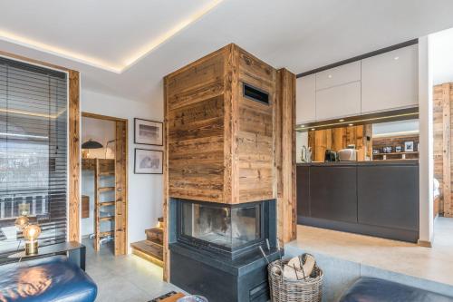 a living room with a fireplace and a kitchen at Superb ski-in apartment in Megève - Welkeys in Megève