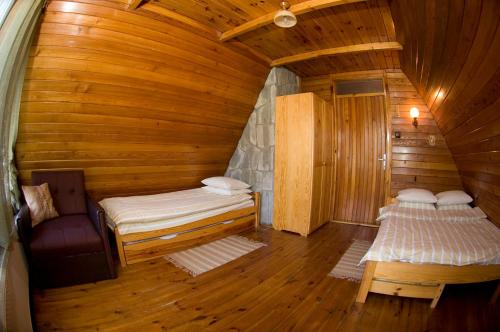 a room with two beds in a wooden cabin at Dom w Szczyrku - stylowy drewniany dom z kominkiem in Szczyrk
