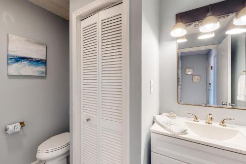 a bathroom with a toilet and a sink and a mirror at Ocean Mile K-3 in St. George Island