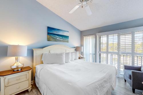 a bedroom with a white bed and a window at Ocean Mile K-3 in St. George Island