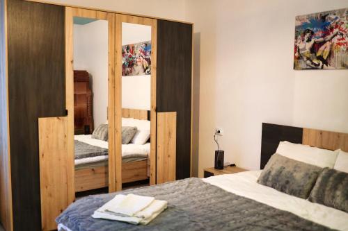 ein Schlafzimmer mit einem Bett und einem großen Spiegel in der Unterkunft Signal Suites with Garden & Mountain View in Braşov