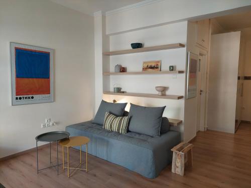 un soggiorno con divano blu e tavolo di Cholargos metro station 2 persons cozy studio. ad Atene