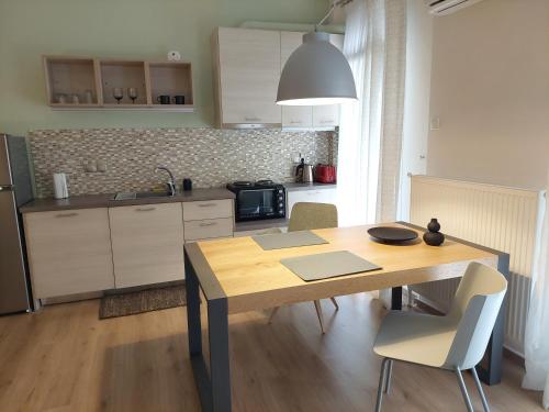 una cucina con tavolo e sedie in legno di Cholargos metro station 2 persons cozy studio. ad Atene