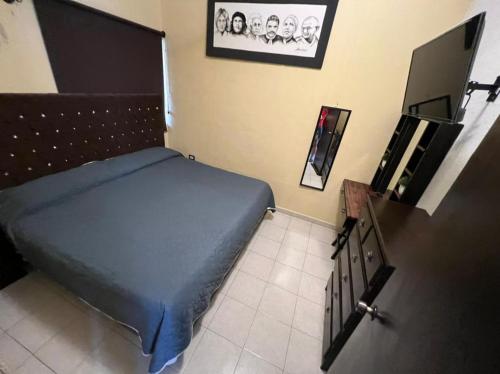 a bedroom with a bed and a flat screen tv at Casa KIRICHNA cerca de centro comercial Y AIRPORT in Chetumal