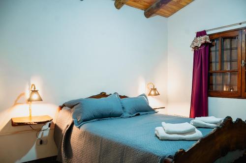 1 dormitorio con 1 cama con toallas en Cabañas Huidun en San Rafael