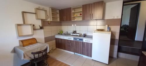 - une cuisine avec des placards en bois et un réfrigérateur blanc dans l'établissement GM Place apartment 60 m2, à Gornji Milanovac