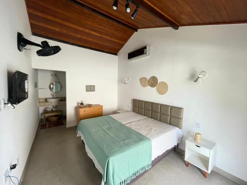 A CASA DA PRAIA DO FORTE في برايا دو فورتي: غرفة نوم بسرير وسقف خشبي