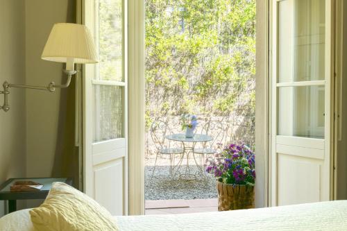 a bedroom with a door open to a patio with a table at Si Montalcino Hotel in Montalcino