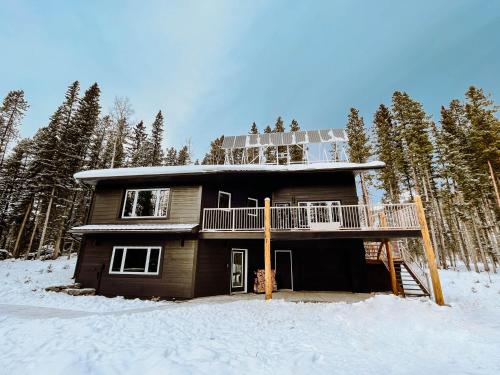 a house with a deck in the snow at Okt Häus in Nordegg