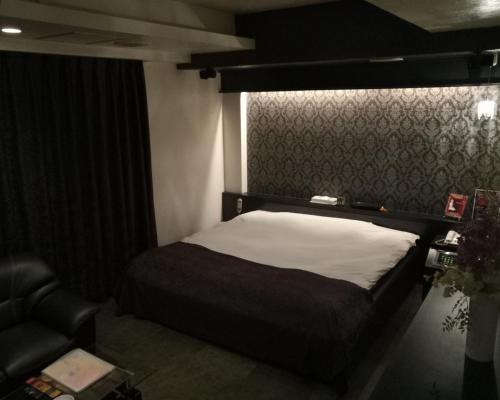 1 dormitorio pequeño con 1 cama y 1 silla en ＳＴＡＲＲＥＳＯＲＴ　Ｉ en Sayama