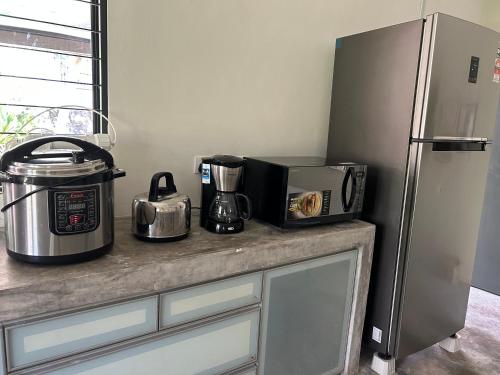 a kitchen counter with a microwave and a refrigerator at Ode to Joy in Serendah