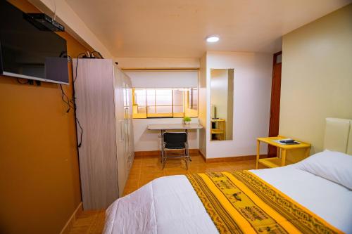 a small room with a bed and a desk at Departamento KIRI para familias con terraza cerca al Aeropuerto de Juliaca in Juliaca