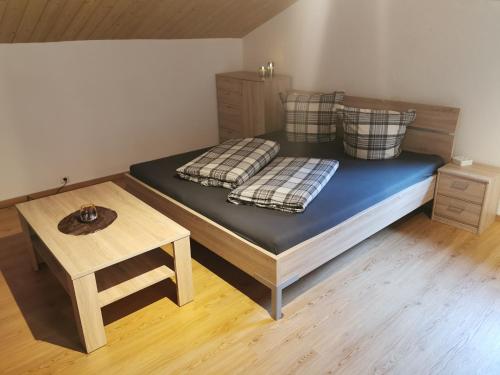 1 cama con 2 almohadas y 1 mesa en una habitación en Großzügige 80m² Wohnung in ruhiger Lage, en Vorderhornbach