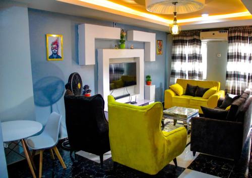 - un salon avec des chaises jaunes et un canapé jaune dans l'établissement A' BASICS APARTMENTS & SUITES, à Ibadan