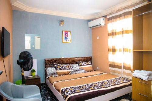ein Schlafzimmer mit einem großen Bett in einem Zimmer in der Unterkunft A' BASICS APARTMENTS & SUITES in Ibadan