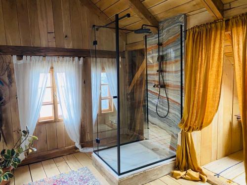 a glass shower in a room with curtains at Estate Ana in Pristava