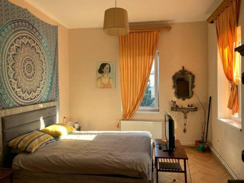 1 dormitorio con 1 cama y escritorio con TV en Cozy Apartment in T'bilisi en Tiflis