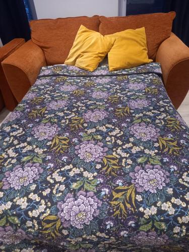 a bed with a colorful bedspread with yellow pillows at Sunny Side - Self Catering Accommodation Gorey in Gorey