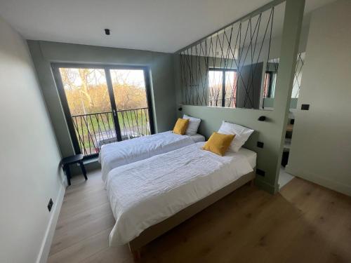 une chambre avec deux lits et une grande fenêtre dans l'établissement MALO - VUE MER - 15 pers - ROOF TOP panoramique, à Dunkerque