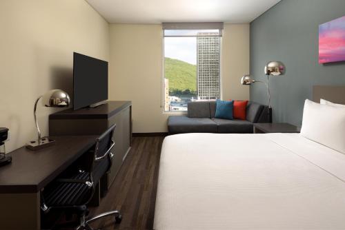 a hotel room with a bed and a desk and a couch at Hyatt House Monterrey Valle San Pedro in Monterrey