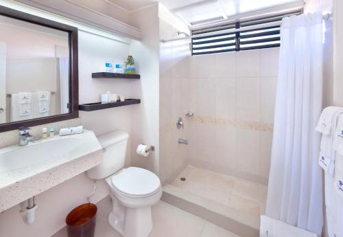 a bathroom with a toilet and a sink and a shower at Blue Horizon Hotel in Bridgetown