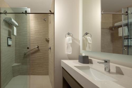 a bathroom with a sink and a glass shower at Hyatt House Monterrey Valle San Pedro in Monterrey