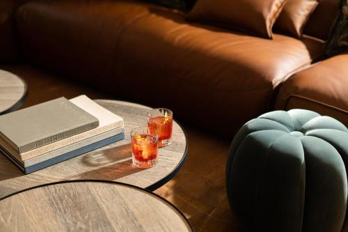 a coffee table with two glasses and a book at Hotel Maribel in Sierra Nevada