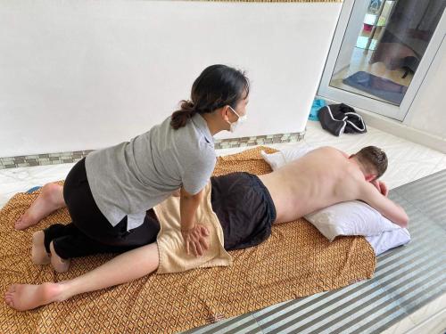 a woman is helping a man laying on the floor at Sunshine Ocean Sea View in Chaweng