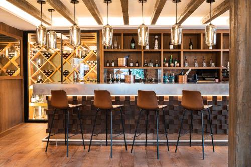 a bar in a restaurant with brown stools at Hotel Maribel in Sierra Nevada