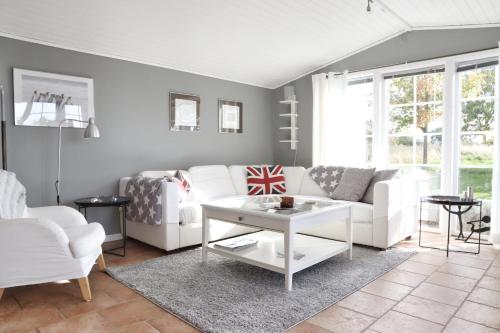 a living room with a white couch and a table at Lantligt boende i idylliska Påarp in Båstad