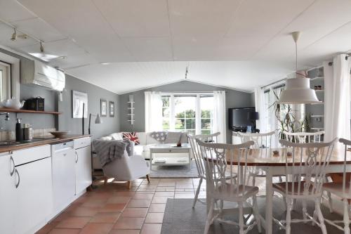 a kitchen and living room with a table and chairs at Lantligt boende i idylliska Påarp in Båstad