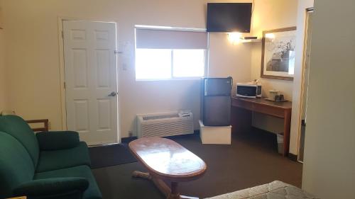 - un salon avec un canapé, une table et un bureau dans l'établissement Calabogie Motor Inn, à Calabogie