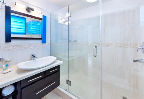 a bathroom with a sink and a glass shower at Blue Horizon Hotel in Bridgetown