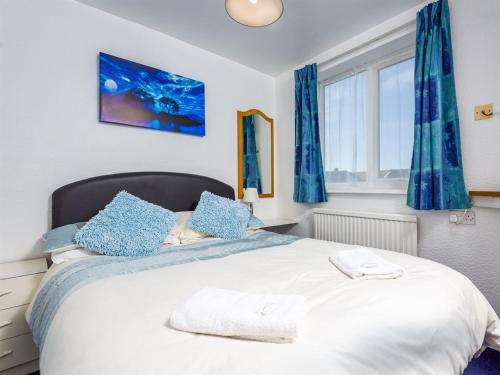 a bedroom with a large white bed with blue curtains at Holmeleigh Hotel in Blackpool