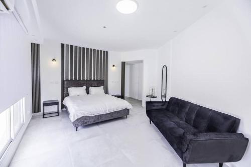 sala de estar con cama y sofá en Luxury Penthouse at Davidka JRSLM, en Jerusalén