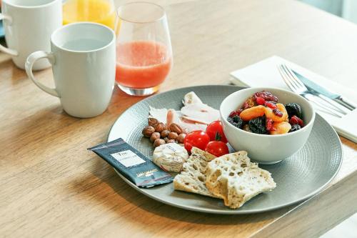 a plate of food on a table with a bowl of food at Hôtel Château des Tourelles - Relais Thalasso & Spa in Pornichet