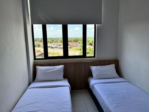 two beds in a room with two windows at Imperio Professional Suite by IMPERIO HAFFA in Alor Setar