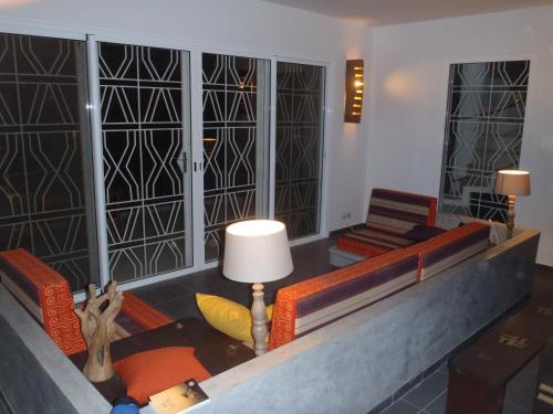 een woonkamer met stoelen en een tafel met een lamp bij Villa avec piscine entre plage et Siné Saloum in Palmarin