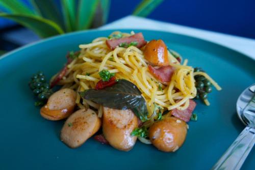 a blue plate of food with pasta and vegetables at USABAI Riverside Boutique Hotel in Chanthaburi