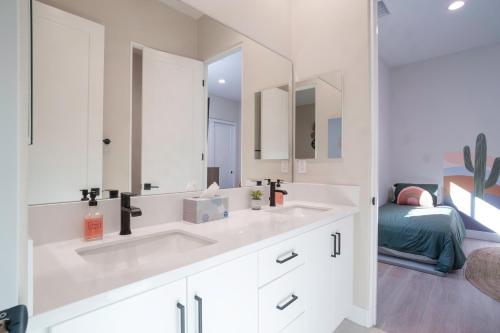 Un baño blanco con lavabo y espejo. en Luxury Rental Signature PGA West Pool Spa Putting green, en La Quinta