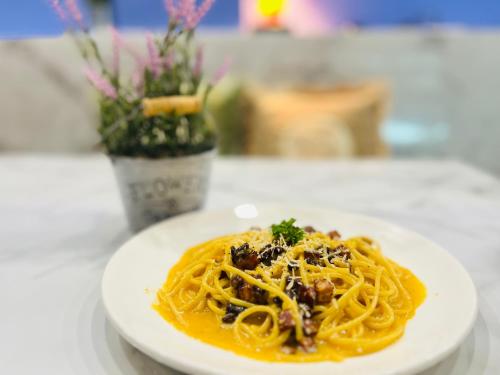 a white plate of pasta on a table at USABAI Riverside Boutique Hotel in Chanthaburi