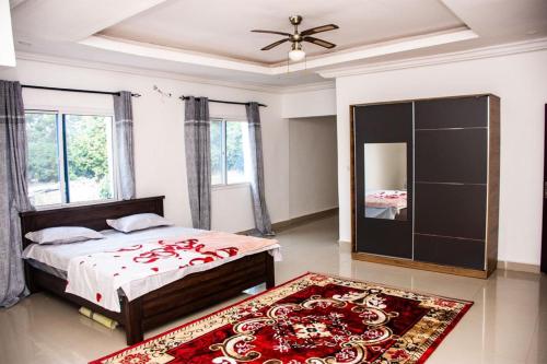 ein Schlafzimmer mit einem Bett und einem großen Spiegel in der Unterkunft Jobz Luxury Rental - White Villa in Brufut