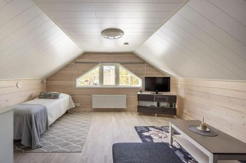 een zolderkamer met een bed en een raam bij Villa Havu holiday home in Pyhä/Lapland in Pyhätunturi