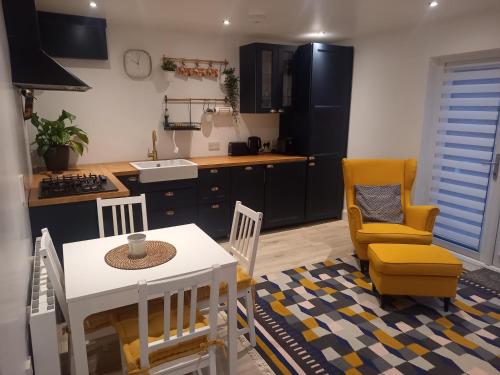 a kitchen with a table and two chairs and a table and a table at Sunny Side - Self Catering Accommodation Gorey in Gorey