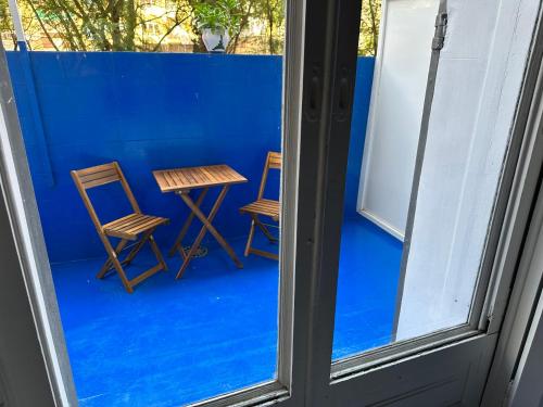 dos sillas y una mesa frente a una pared azul en Hostel Friends Barcelona, en Barcelona