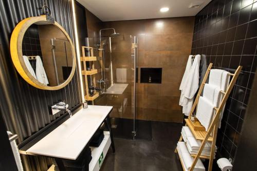 a bathroom with a sink and a mirror and a shower at Dark Studio in São Roque